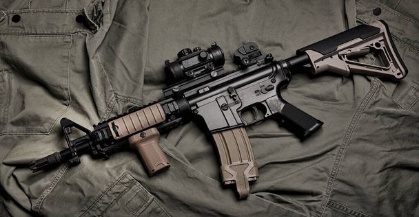 Armas y equipo militar para el ejército, Asalto rifle pistola (M4A1) sobre fondo uniforme militar verde. - Foto, Imagen