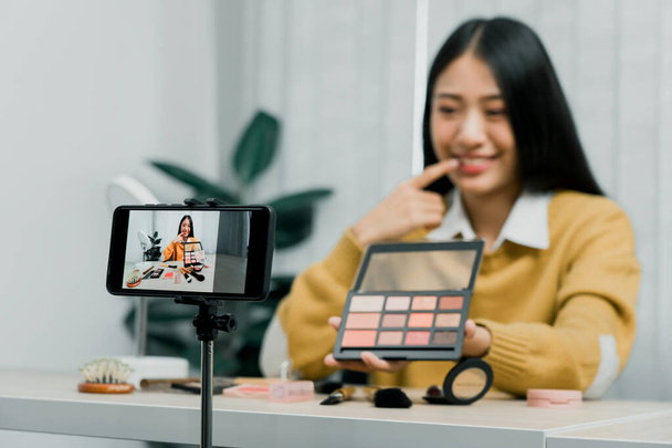 Asiatiques adolescentes faisant maquillage vlogs et en utilisant une caméra vidéo mobile pour enregistrer vlogs et les publier en ligne à la maison. - Photo, image