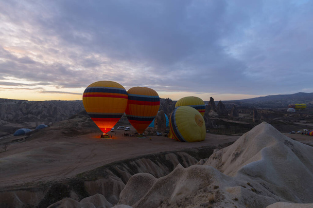 Surise vista del paesaggio roccioso insolito in Cappadocia, Turchia. Palloni aerostatici colorati volano nel cielo azzurro sopra incredibili valli con camini fatati in Cappadocia. - Foto, immagini