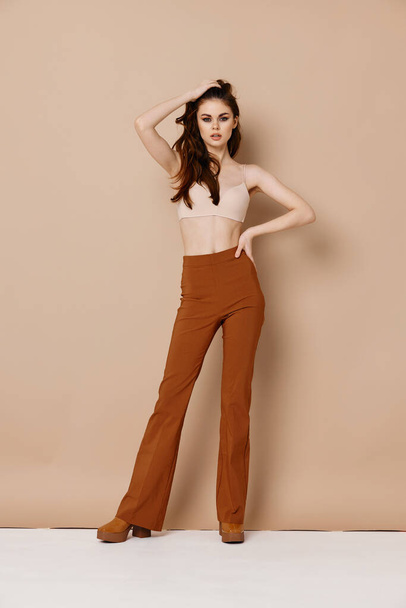 woman in short t-shirt trousers and shoes on beige background clean leather spa treatments - Photo, image