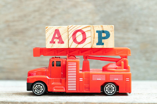 Tűzlétrás teherautó levéltartó blokk a szó AOP (rövidítése éves működési terv vagy Aspect-orientált programozás) a fa háttér - Fotó, kép