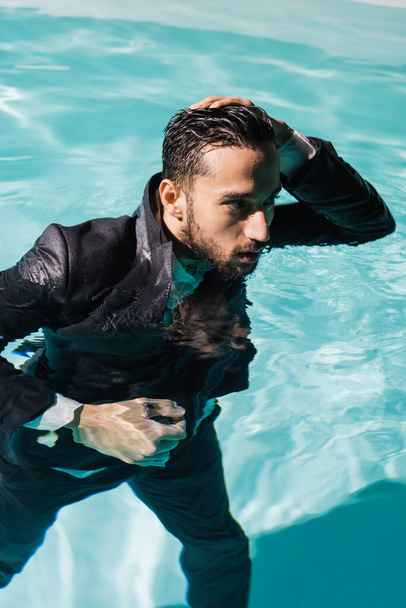 Arabian businessman swimming in pool with turquoise water  - Fotografie, Obrázek