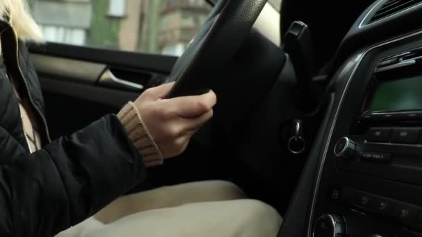 Meisje rijdt haar auto in beweging close-up, handen op het stuur - Video