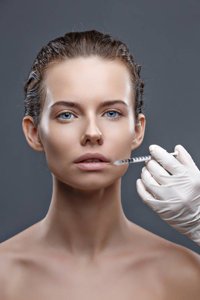 The doctor cosmetologist makes the Rejuvenating facial injections procedure for tightening and smoothing wrinkles on the face skin of a women in a beauty salon. Cosmetology skin care - Fotó, kép