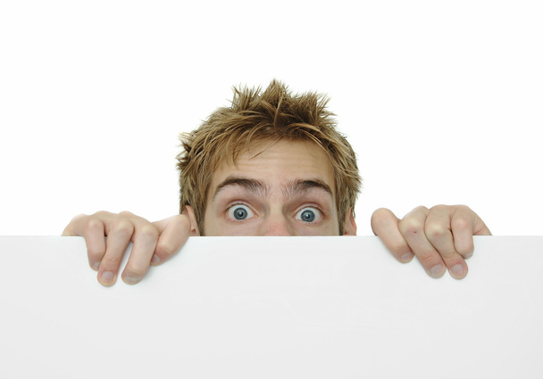 Young adult peeking above white sign - Φωτογραφία, εικόνα