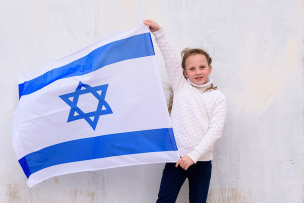 Kis hazafi zsidó lány zászló Izrael fehér háttér. - Fotó, kép