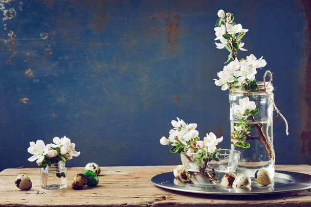 Apfelblütenblumen, Wachteleier auf einem Holztisch. Frühlingsstillleben. - Foto, Bild