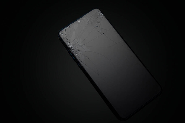 Cristal de pantalla rota de teléfono inteligente móvil sobre fondo negro - Foto, Imagen