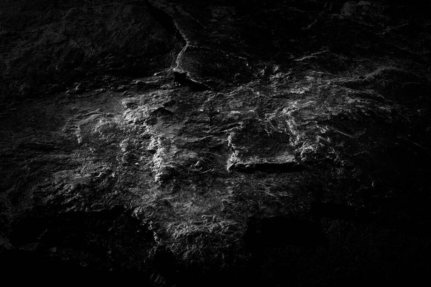 Közelkép fekete kopott texturált kő felületi háttér. Szikla textúra részlet. Geológia és hegymászás. Absztrakt grunge háttér tervezők. - Fotó, kép