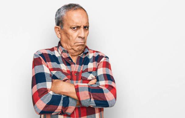 Senior hispanic man wearing casual clothes skeptic and nervous, disapproving expression on face with crossed arms. negative person.  - Photo, Image