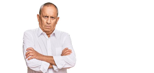 Handsome senior man wearing elegant white shirt skeptic and nervous, disapproving expression on face with crossed arms. negative person.  - Photo, Image