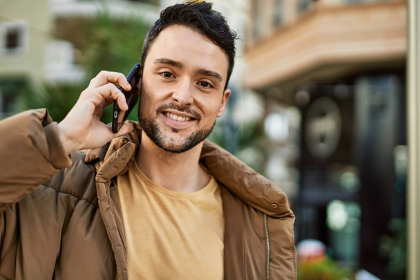 Young hispanic man smiling happy talking on the smartphone at the city. - Photo, image