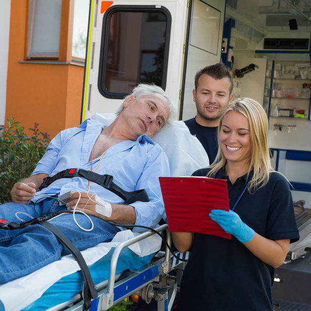 Emergency team treating patient on stretcher - Fotoğraf, Görsel