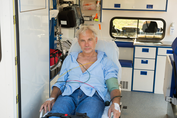 Injured man on stretcher in ambulance - Foto, afbeelding
