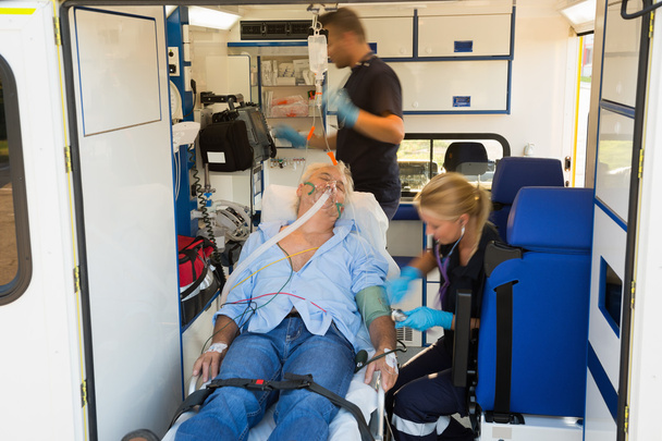 Paramedics treating man in ambulance - Fotoğraf, Görsel