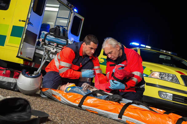 Paramedics giving firstaid to motorbike driver - Foto, Bild