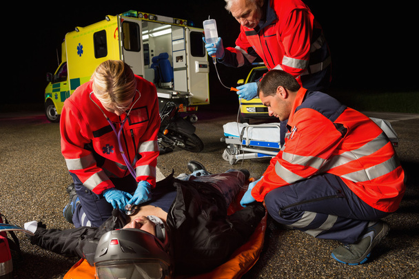 Emergency team helping injured driver - Foto, Bild
