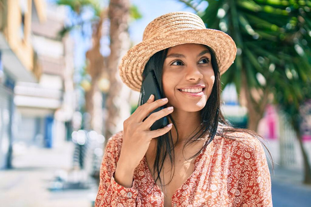若いアフリカ系アメリカ人の観光客の女性が市内のスマートフォンで話しています. - 写真・画像