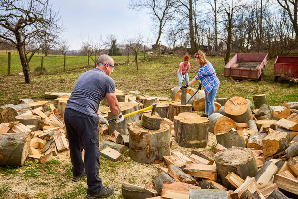 сім'я працює разом, щоб підготувати дрова на зиму
 - Фото, зображення