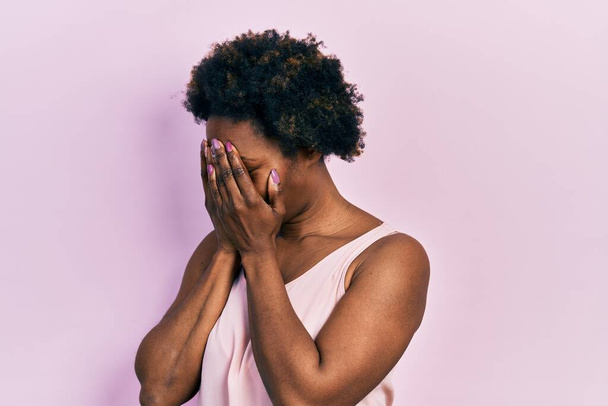 Young african american woman wearing casual sleeveless t shirt with sad expression covering face with hands while crying. depression concept.  - Photo, Image