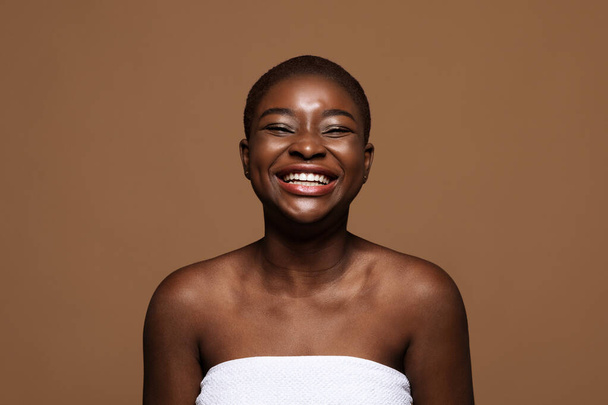 Akceptacja siebie. Śmiejąca się Afroamerykanka z krótkimi włosami i idealną skórą - Zdjęcie, obraz