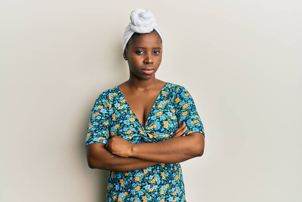 Jeune femme africaine portant un turban capillaire et un style africain sceptique et nerveux, désapprouvant l'expression sur le visage avec les bras croisés. personne négative.  - Photo, image