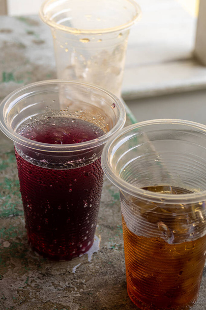 Boisson gazeuse et glace dans les verres jetables en plastique - Photo, image