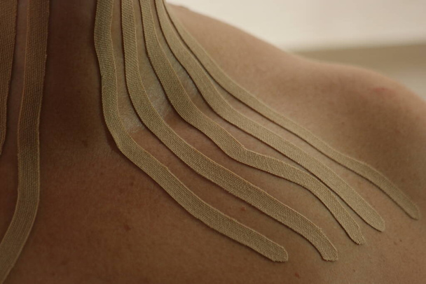 Primer plano de las cintas de kinesio en el pecho de una mujer. - Foto, Imagen