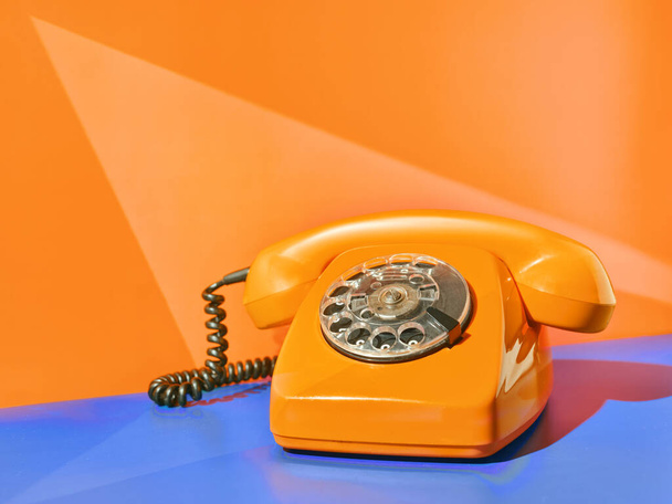 Vintage yellow telephone on the table - 写真・画像