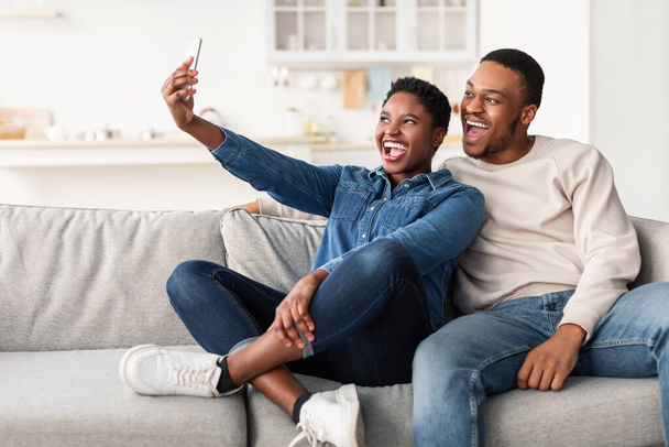 Portret van zwart paar nemen selfie samen thuis - Foto, afbeelding