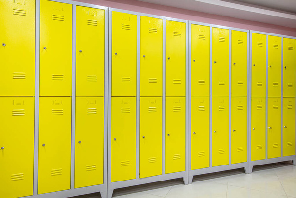Armarios de metal amarillo en la sala de armarios extrema. Armarios metálicos amarillos. Volver al contexto escolar. - Foto, imagen