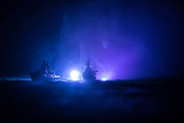 Válečný koncept. Noční bitevní scéna na moři. Dramatický efekt tónovaných mraků. Silueta bitevní lodi v noci. Miniaturní kreativní stolní dekorace. Selektivní zaměření - Fotografie, Obrázek