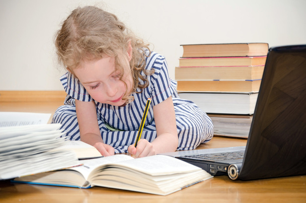 Smart little girl writes diploma at home. - Photo, Image