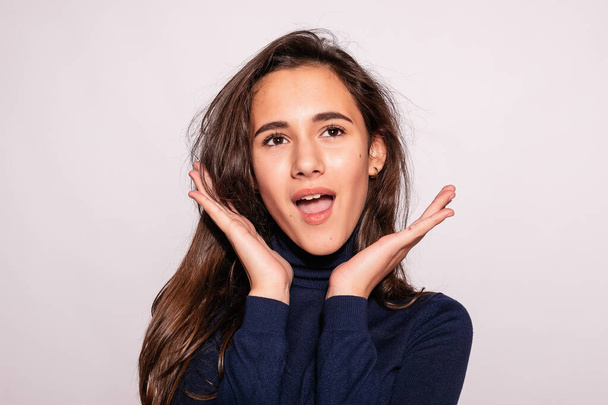 Trendy beautiful hipster girl. Photo of positive young nice woman in blue knee-high socks with white background. looks at the camera. surprised with his hand and look up - Foto, Bild