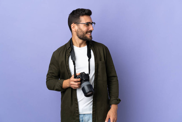 Photographer man over isolated purple background looking side - Foto, Imagem