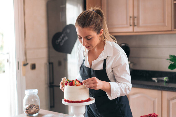 Nuori kondiittori ruoanlaitto perinteinen punainen sametti kakku keittiössä - Valokuva, kuva