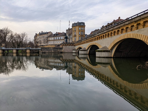 Günün sonunda Metz 'de, nehir manzaralı, köprü manzaralı ve arka planda eski binalar olan bir çekim. - Fotoğraf, Görsel