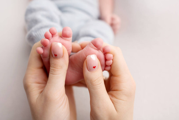 Vastasyntyneen jalat ovat äidin käsissä. Ei. Äiti pitää vauvojen jalkoja käsissään. Onnellinen perheen käsite. - Valokuva, kuva