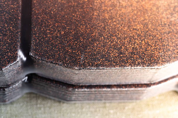 Brązowe półpasiec bitumiczny zapakowane w oryginalne opakowanie z bliska. Materiał dachowy do pokrycia dachu domu - Zdjęcie, obraz