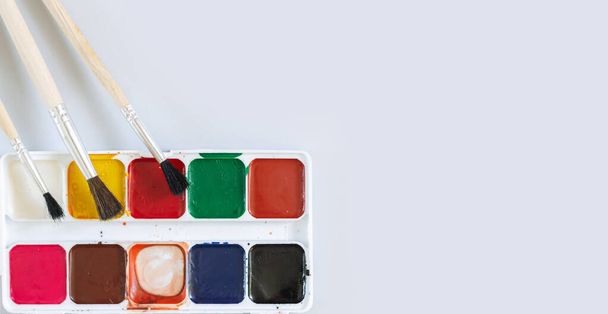 Кисти с использованием палитры акварельной краски готовы к покраске вид сверху - Фото, изображение