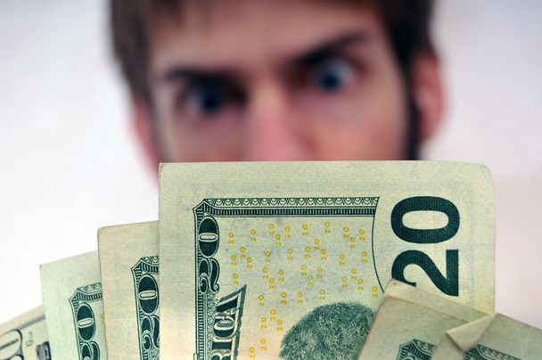 Homem a olhar para um maço de dinheiro
 - Foto, Imagem