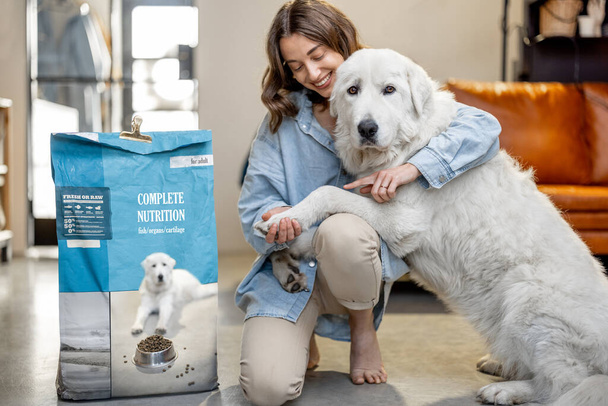 Femme nourrir chien avec une nourriture sèche à la maison - Photo, image
