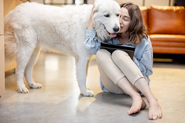 Γυναίκα με σκύλο και ψηφιακή ταμπλέτα στο σπίτι - Φωτογραφία, εικόνα