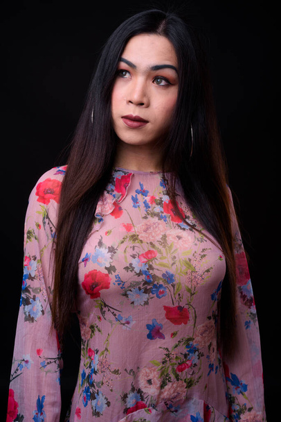 Young beautiful Asian transgender woman against black background - Fotografie, Obrázek