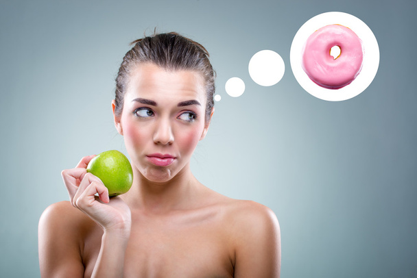 A Dieta! Mulher comendo uma maçã, mas ele acha que um donut
 . - Foto, Imagem