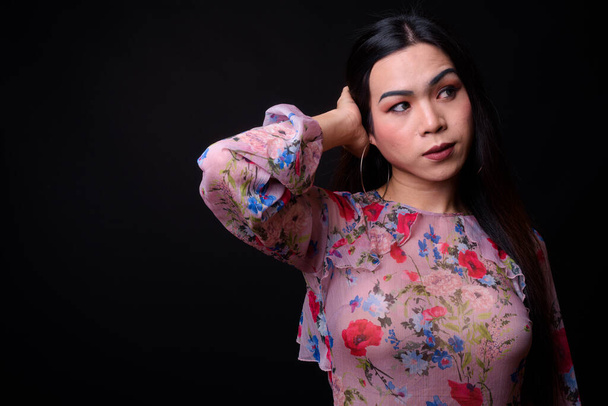 Young beautiful Asian transgender woman against black background - Valokuva, kuva
