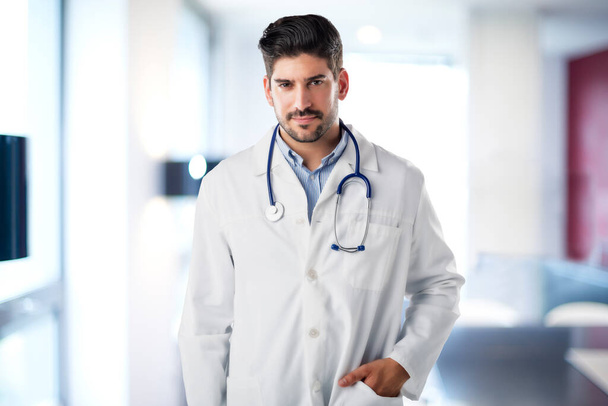 Male doctor portrait while standing at the hospital foyer. - Valokuva, kuva