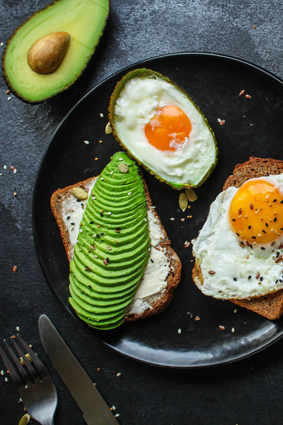 top view of fried eggs with avocado on a black background. top view. - Foto, immagini