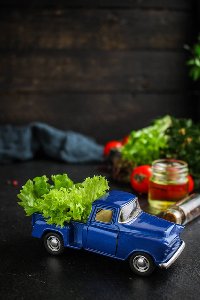 La ensalada sana - las hojas de lechuga, los tomates, hortalizas (las vitaminas los ingredientes. juguete coche) concepto de menú. antecedentes alimenticios. Vista superior. espacio de copia - Foto, Imagen
