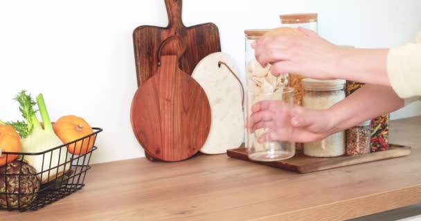Frau stellt Nudeln aus Baumwolltasche in Glasgefäße. Mehrwegbeutel für Produkte, Null-Abfall-Konzept - Filmmaterial, Video